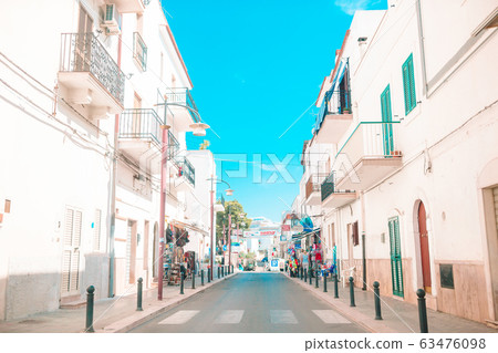 The narrow streets of the island with blue balconies, stairs and flowers. 63476098