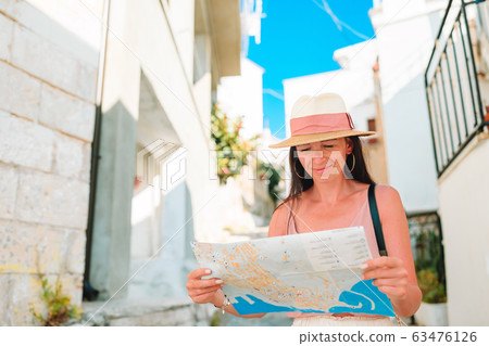 Girl tourist with a city map outdoors 63476126