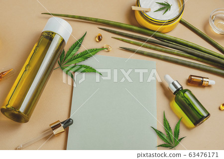Cosmetics with hemp CBD oil on a beige background, notebook, marijuana leaves. Copy space, mockup Cosmetics with hemp CBD oil on a beige background, notebook, marijuana leaves. Copy space, mockup 63476171