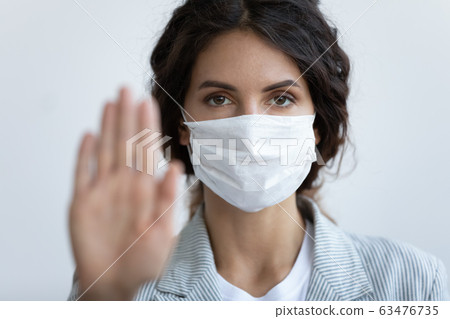 On blue background female face in mask and stretched hand 63476735