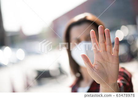 Close up of woman wearing protective face mask 63478978