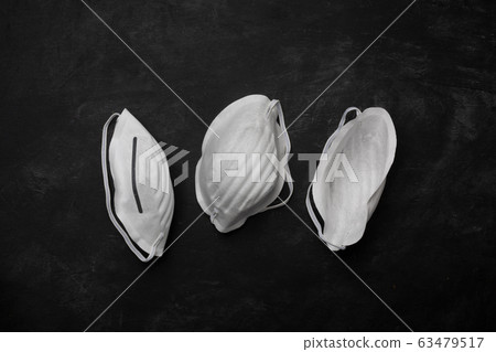 Anti coronavirus Covid-19 protective mask on dark background, horizontal Anti coronavirus Covid-19 protective mask on dark background, horizontal 63479517