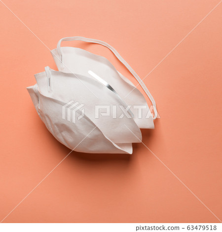 Anti coronavirus Covid-19 protective mask on orange background Anti coronavirus Covid-19 protective mask on orange background 63479518