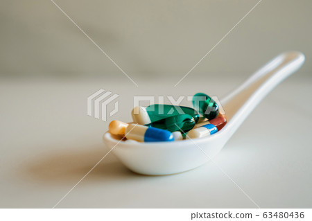 Mixed of pill or tablet medicine on white spoon on Mixed of pill or tablet medicine on white spoon on 63480436