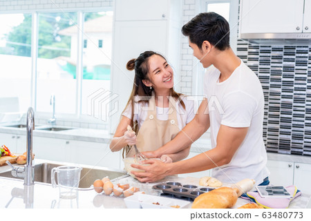 Happy Asian couples cooking and baking cake Happy Asian couples cooking and baking cake 63480773