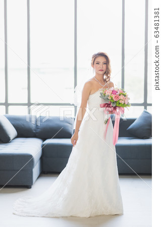 Asian bride standing and holding a bouquet.. 63481381