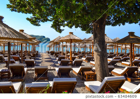 The beach with straw umbrellas from the sun and The beach with straw umbrellas from the sun and 63484609