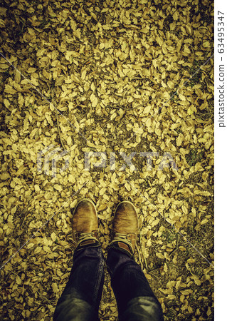 Feet in fallen leaves 63495347