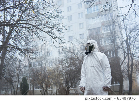Scientist in safety respirator standing on the street. 63497976