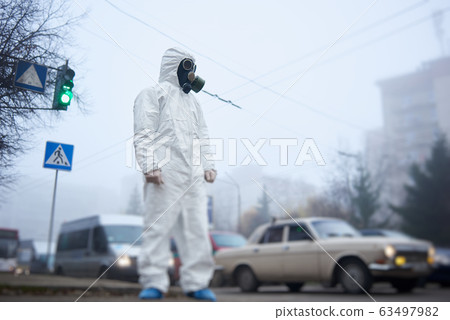 Ecologist in protective suit standing on the street. 63497982