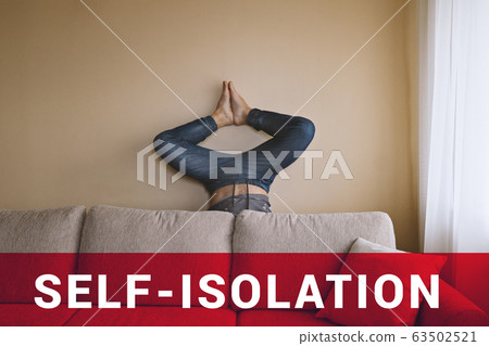 Man handstanding behind beige couch. Self-isolation during coronavirus 63502521