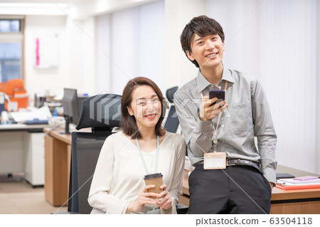 Portrait of female boss and young male employee in office 63504118