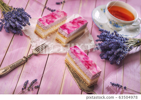 lavender cake served on pink background with flowers and cup of tea, vintage background with cake lavender cake served on pink background with flowers and cup of tea, vintage background with cake 63504978