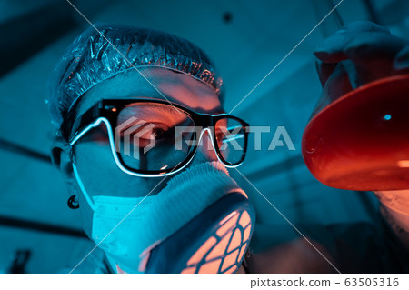Young male researcher carrying out scientific experiment. 63505316