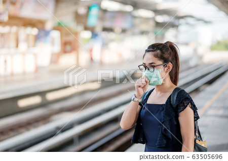 young Asian woman wearing Surgical face mask 63505696