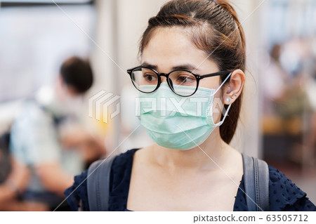 young Asian woman wearing Surgical face mask 63505712