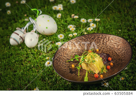 fresh spring appetizer with cheese and herbs served on green grass with flowers, product photography for restaurant  63505884