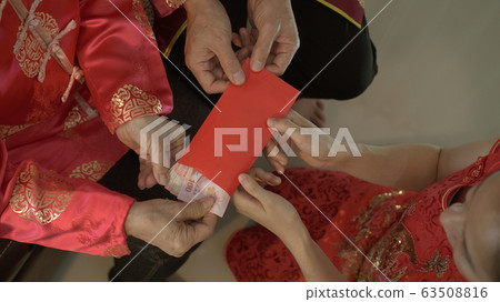 Giving red envelop for Chinese New Year Top view grandparent and five money to children Giving red envelop for Chinese New Year Top view grandparent and five money to children 63508816