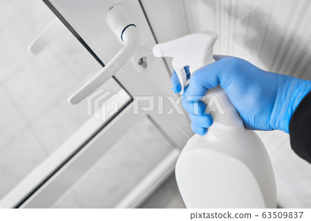 Disinfection, cleaning and washing of door handles. COVID-19. Prevention of coronavirus infection. closeup of a disinfecting the door handle by spraying a sanitizer from a white bottle Disinfection, cleaning and washing of door handles. COVID-19. Prevention of coronavirus infection. closeup of a disinfecting the door handle by spraying a sanitizer from a white bottle 63509837