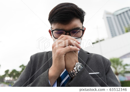 Close up of a businessman in a suit wearing Protective face mask Close up of a businessman in a suit wearing Protective face mask 63512346