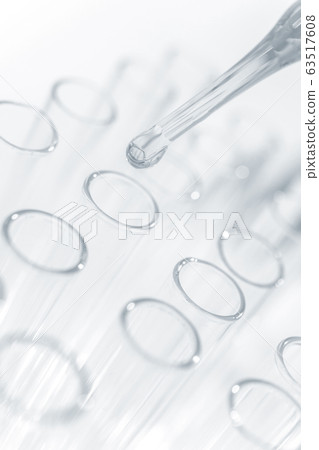 Drops chemical liquid into test tube in laboratory close up, black and white theme Drops chemical liquid into test tube in laboratory close up, black and white theme 63517608