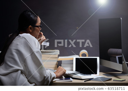 Girl in white shirt reading many textbooks on 63518711