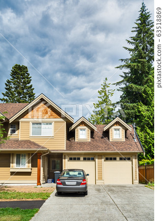 Luxury residential house with car parked in front on cloudy sky background 63518869