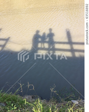 父母和孩子的影子反映在池塘 父母和孩子的影子反映在池塘 63518892