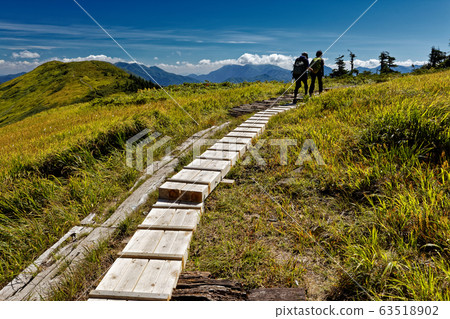 Climbers going down the autumn winding machine ridgeline 63518902