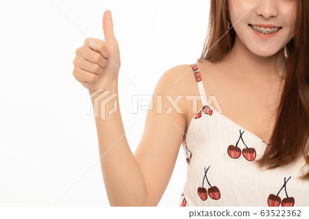 Portrait of successful asian girl pointing thumb up; asian woman young adult model on white background. Portrait of successful asian girl pointing thumb up; asian woman young adult model on white background. 63522362