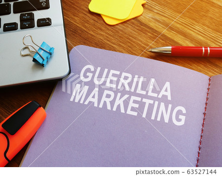 Guerilla marketing guide and laptop on the desk. 63527144