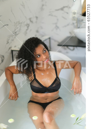 Black gladden girl sittling in bath and wearing underwear. Black gladden girl sittling in bath and wearing underwear. 63527733