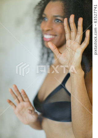 Portrait of black cute girl wearing bra and touching glass in bathroom. 63527741