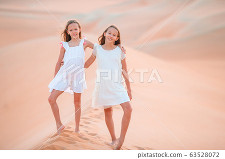 Girls among dunes in big desert in Emirates Girls among dunes in big desert in Emirates 63528072