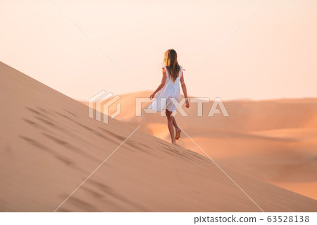 Girl among dunes in desert in United Arab Emirates 63528138