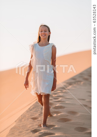 Girl among dunes in desert in United Arab Emirates Girl among dunes in desert in United Arab Emirates 63528143