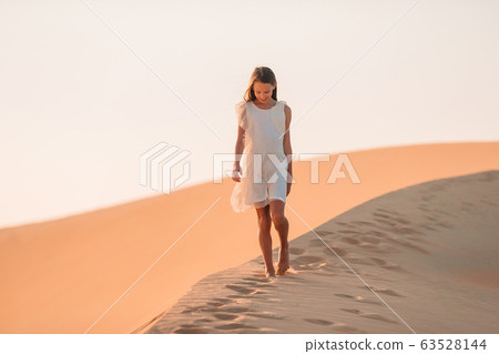 Girl among dunes in desert in United Arab Emirates 63528144
