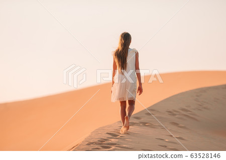 Girl among dunes in desert in United Arab Emirates 63528146
