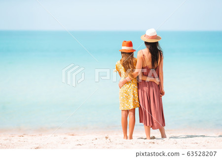 Beautiful mother and daughter at the beach enjoying summer vacation. Beautiful mother and daughter at the beach enjoying summer vacation. 63528207