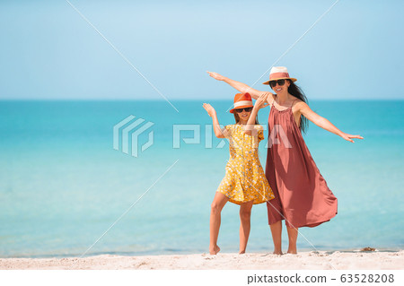 Beautiful mother and daughter on the beach Beautiful mother and daughter on the beach 63528208