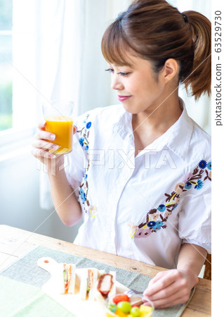 女人在窗邊喝橙汁 63529730