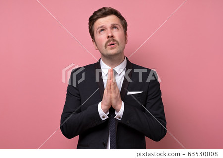 Caucasian man with mustache showing clasped hands, 63530008