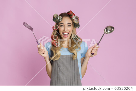 Housewife in striped apron isolated on pink wall background Housewife in striped apron isolated on pink wall background 63530204