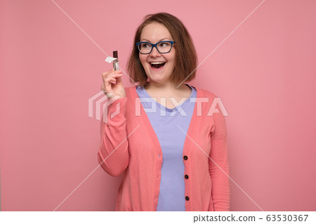 Young happy smiling woman wanting to eat chocolate 63530367