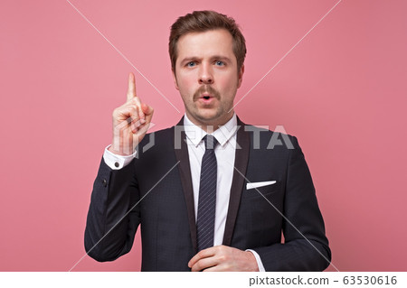 Handsome happy young businessman raising up his Handsome happy young businessman raising up his 63530616