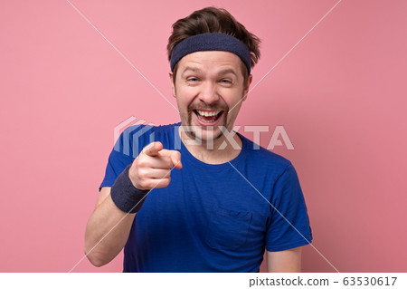 Young caucasian man in sport wear pointing and 63530617