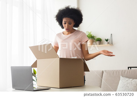 Mistake with order from online shop. Upset woman spreads hands 63530720