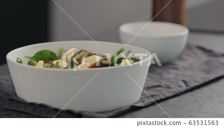 cheese chunks to salad with kumato tomatoes and spinach in white bowl cheese chunks to salad with kumato tomatoes and spinach in white bowl 63531563