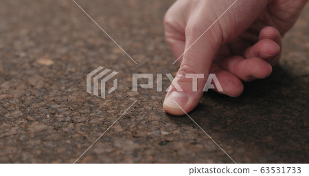 man hand touch dark cork surface with oil finish 63531733