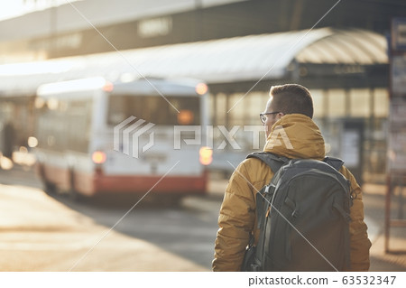 Passenger walking to bus stop 63532347